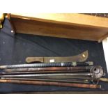 A bundle of swords, gun cleaning rods, machete etc.