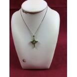 A Sterling silver necklace hung with a peridot set cross pendant
