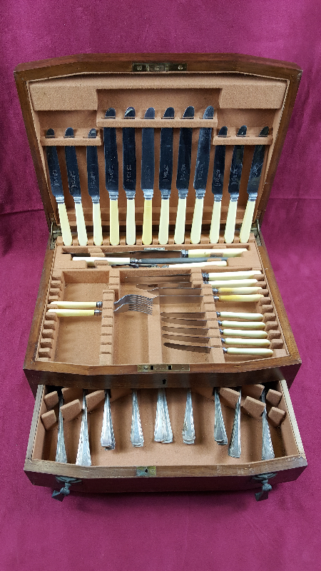 An Art Deco mahogany cased part canteen of silver plated cutlery