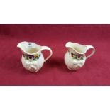 A pair of Belleek floral decorated jugs