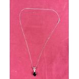A Sterling silver black spinel garnet and diamond set pendant hung to a fine link chain