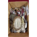 A box containing a tin mould and various cutlery