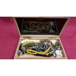 A wooden box of various costume jewellery