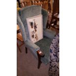 A green upholstered wing back armchair