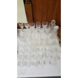 A quantity of various cut glass drinking glasses and two decanters and stoppers