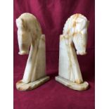 A large pair of onyx bookends in the form of horses' heads