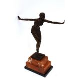 A bronzed Art Deco design figure of a 1920's dancing girl, raised on a rouge and black marble