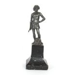 An Art Deco cast metal figure of a warrior holding a sword above a severed head, raised on a