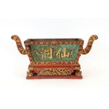 A large antique Chinese wooden red painted and gilded censer or wine cooler, having foliate