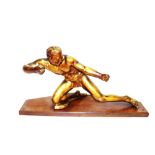 An Art Deco gilded figure of an archer (bow missing), raised on a wooden plinth, 76cm long