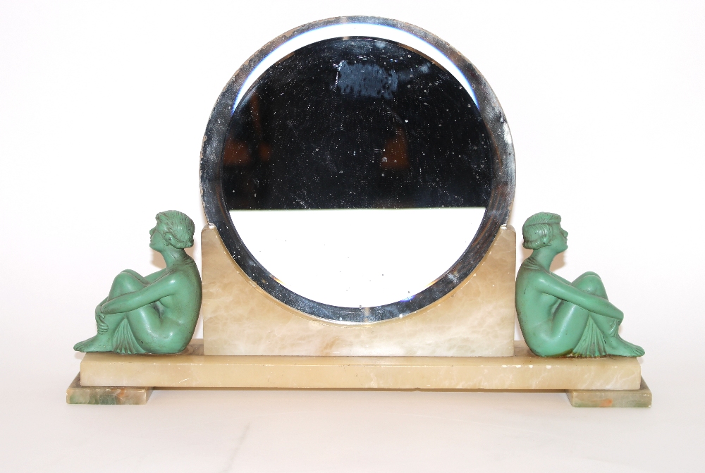 An Art Deco circular bevelled wall mirror on alabaster base, flanked by painted metal seated semi