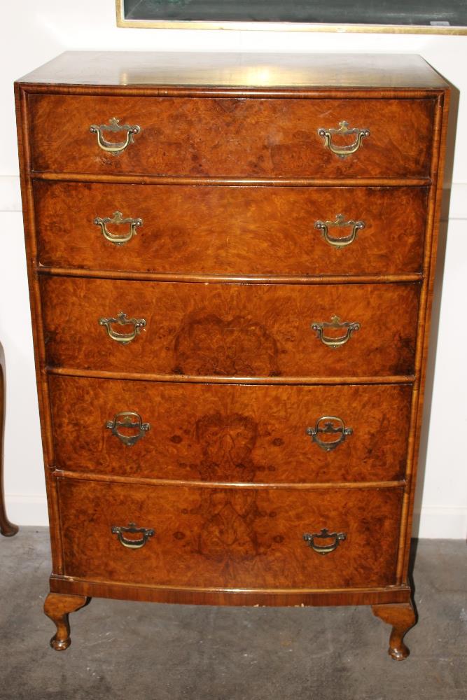 A 20th Century walnut and cross banded bow fronted chest, fitted five long drawers raised on