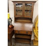 An Arts & Crafts oak bureau bookcase, the upper section enclosed by a pair of glazed leaded light