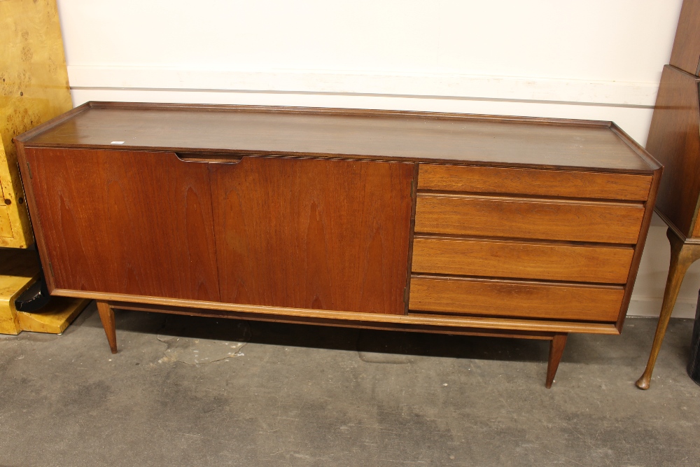 A G-plan design teak sideboard, fitted double cupboards flanked by four long drawers raised on