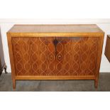 A teak and inlaid Danish design side cabinet, enclosed by a pair of panelled doors with stylised