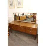 A G-plan design dressing table, fitted oblong mirror and six drawers raised on rounded tapering