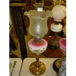 A Victorian brass oil lamp with ruby glass and pai