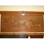 A carved oak panel depicting a family of birds