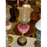 A Victorian brass oil lamp with ruby glass reservo