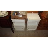 A pair of white bedside cupboards