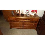 A reproduction yew wood multi drawer sideboard