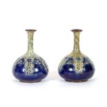 A pair of Doulton stoneware baluster vases, with trumpet shaped necks above stylised floral