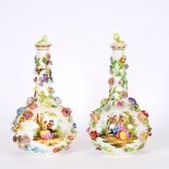 A pair of 19th Century German porcelain bottle vases and covers, having profuse floral encrusted