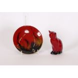 A Royal Doulton flambe model of a seated cat, 13cm high;and a Doulton flambe saucer, (2)