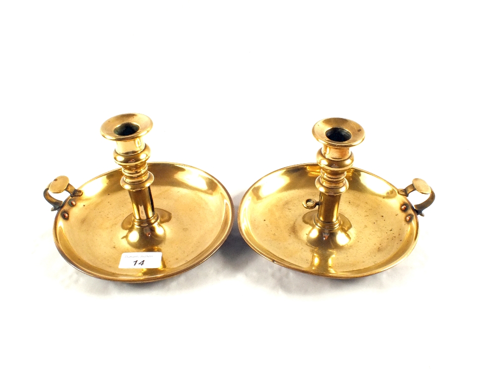 A pair of 19th Century Brass chambersticks with wide circular bases