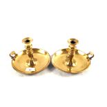 A pair of 19th Century Brass chambersticks with wide circular bases