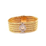 An 18ct Gold and Diamond set lady's universal Geneve watch in the form of a large meshwork bracelet