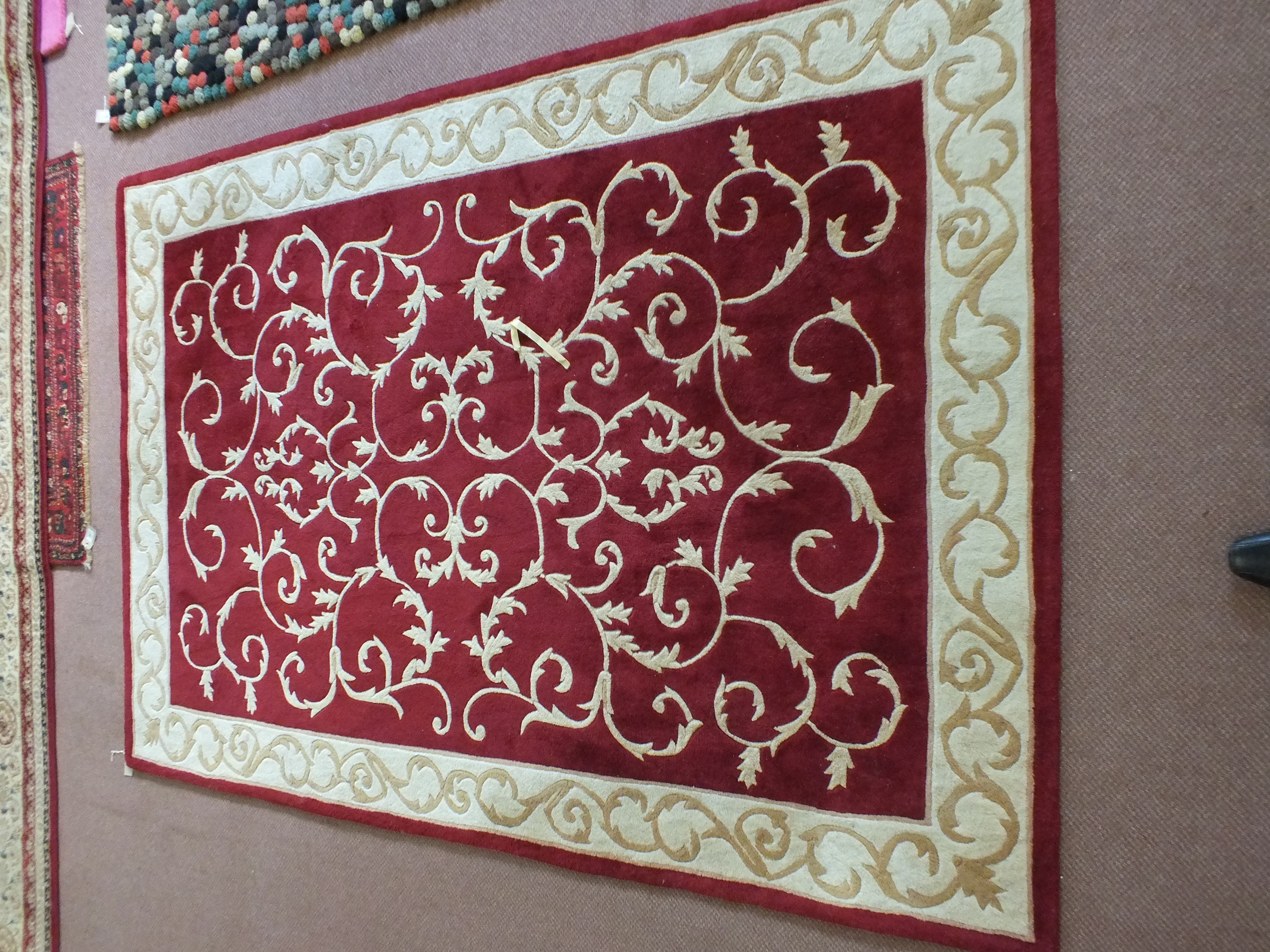 A Chinese maroon and cream floral rug,
