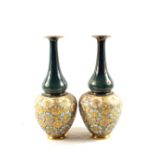 A pair of Doulton Lambeths Slaters pattern floral vases on green ground,