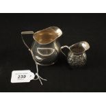 A Silver cream jug, Birmingham 1903 and a miniature jug with floral embossed decoration,