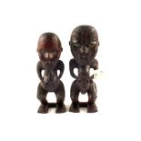 Two traditionally carved wooden Maori figures of a male and female with shell eyes