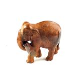An Indian wooden Elephant carrying a log