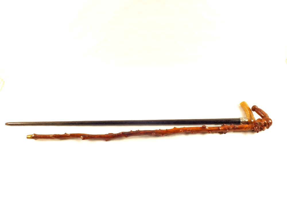 A gents walking cane with Silver band and horn grip plus a natural wooden stick with carved - Image 2 of 2