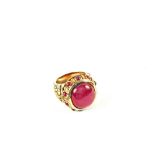 A large cabochon Ruby set ring with Ruby and Diamond border with decorated shoulders, stamped 14K,