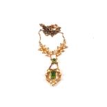 A 15ct Gold Peridot and Seed Pearl set Art Nouveau style pendant hung from a two toned yellow metal