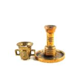 A heavy antique Bronze candlestick with wide dished base and a miniature Brass mortar with raised