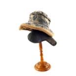A turned wooden Haberdashery stand and a hat