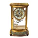 An Onyx and gilt metal glass sided mantel clock