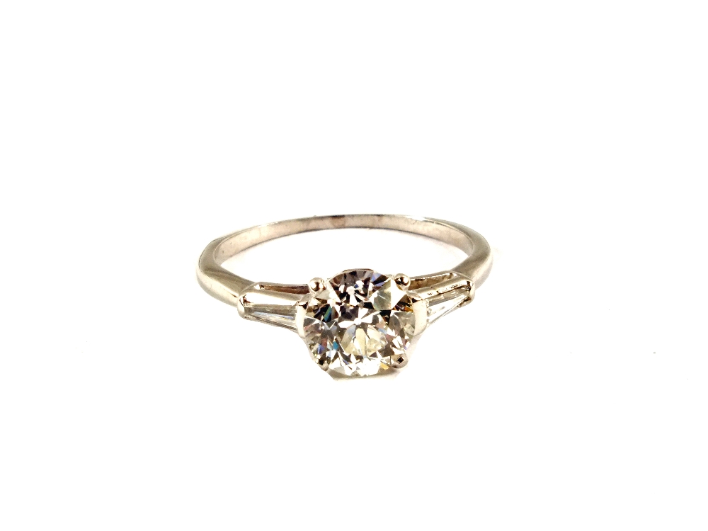 A large solitaire Diamond ring, the shoulders set with a baguette cut Diamond each side,