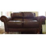 A brown leather two seater sofa and armchair