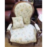 A Victorian Mahogany spoonback armchair with floral upholstery on cabriole legs