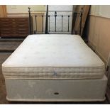 A double divan with a Brass effect metal headboard and mattress