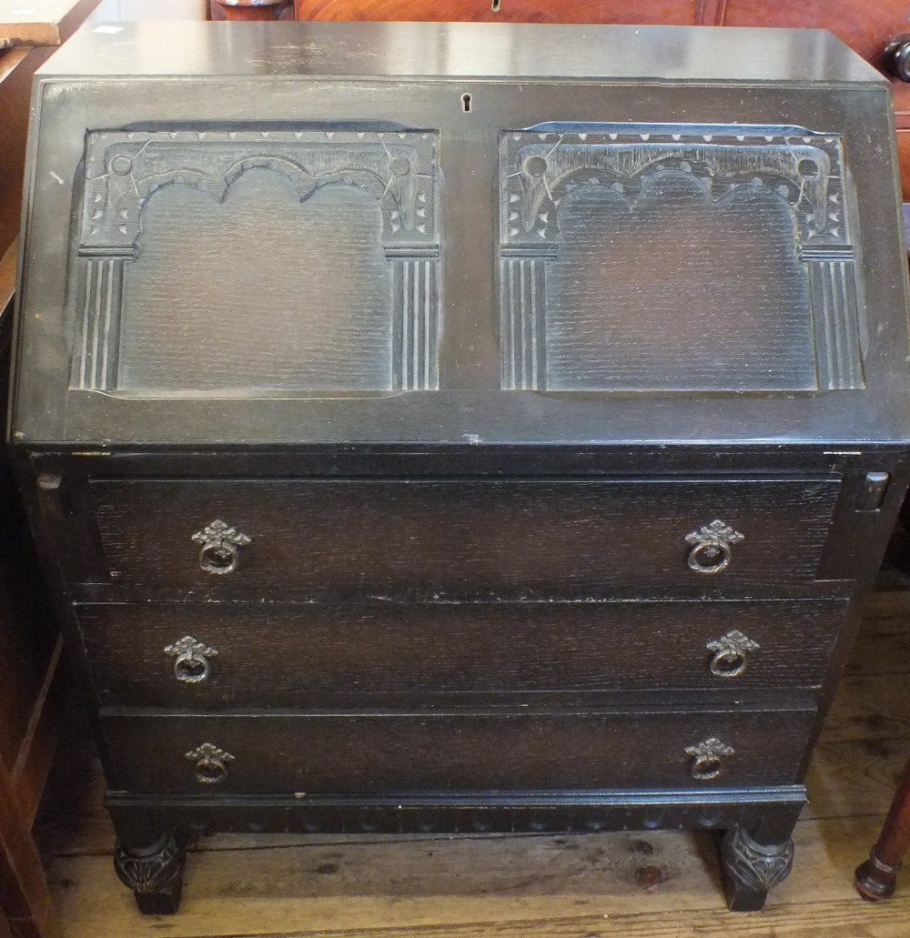 A carved Oak three drawer bureau