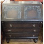 A carved Oak three drawer bureau