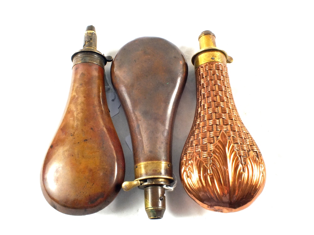 A group of three powder flasks,