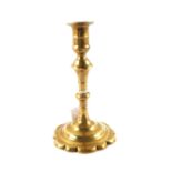 An 18th Century Brass candlestick with knopped stem and petal base,